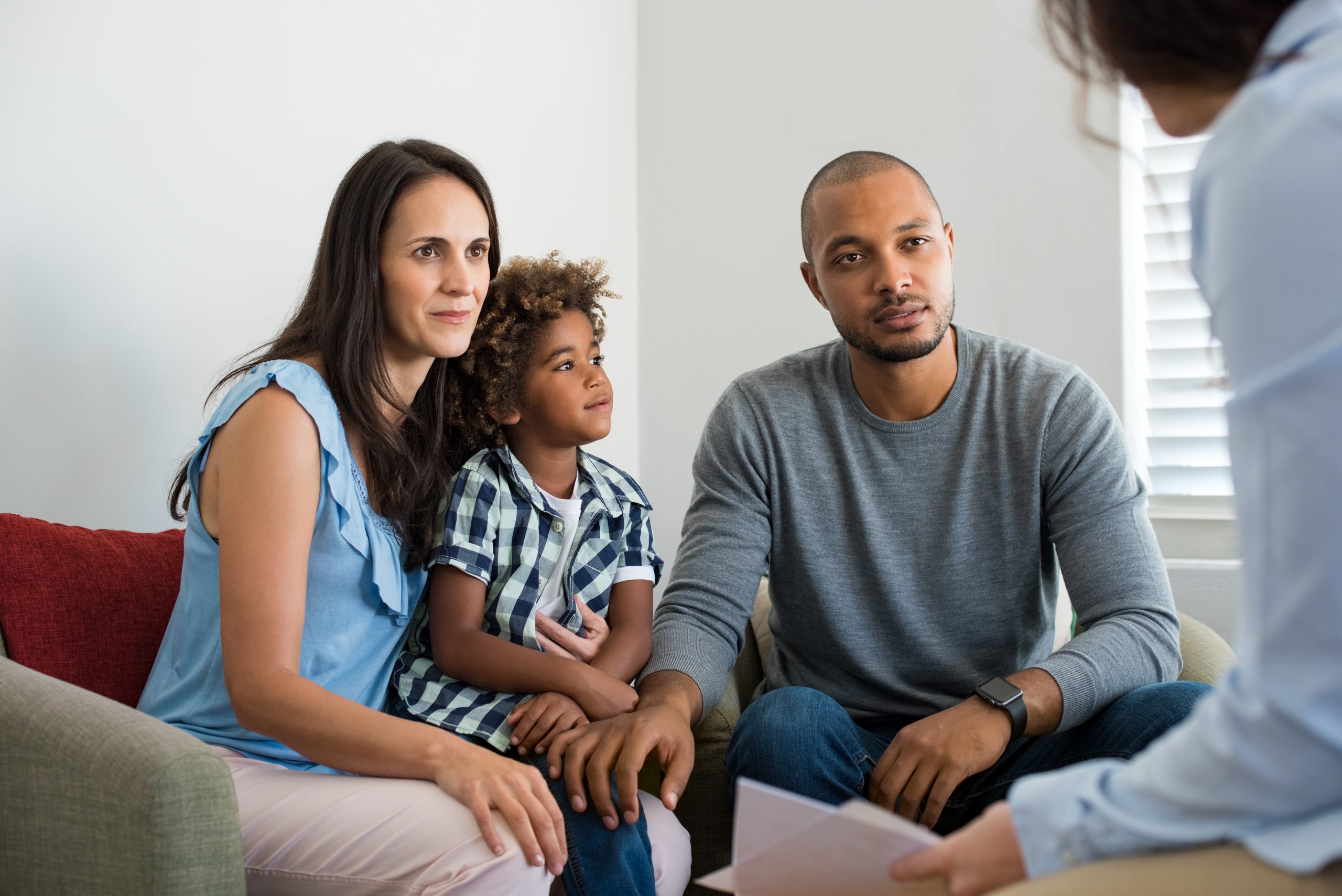 Couple sitting with their young child while talking with a family counselor
