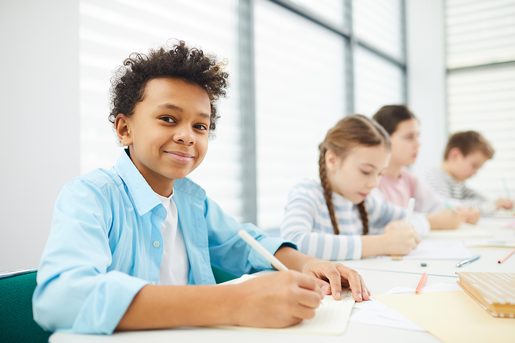 Boy sitting next to classmates
