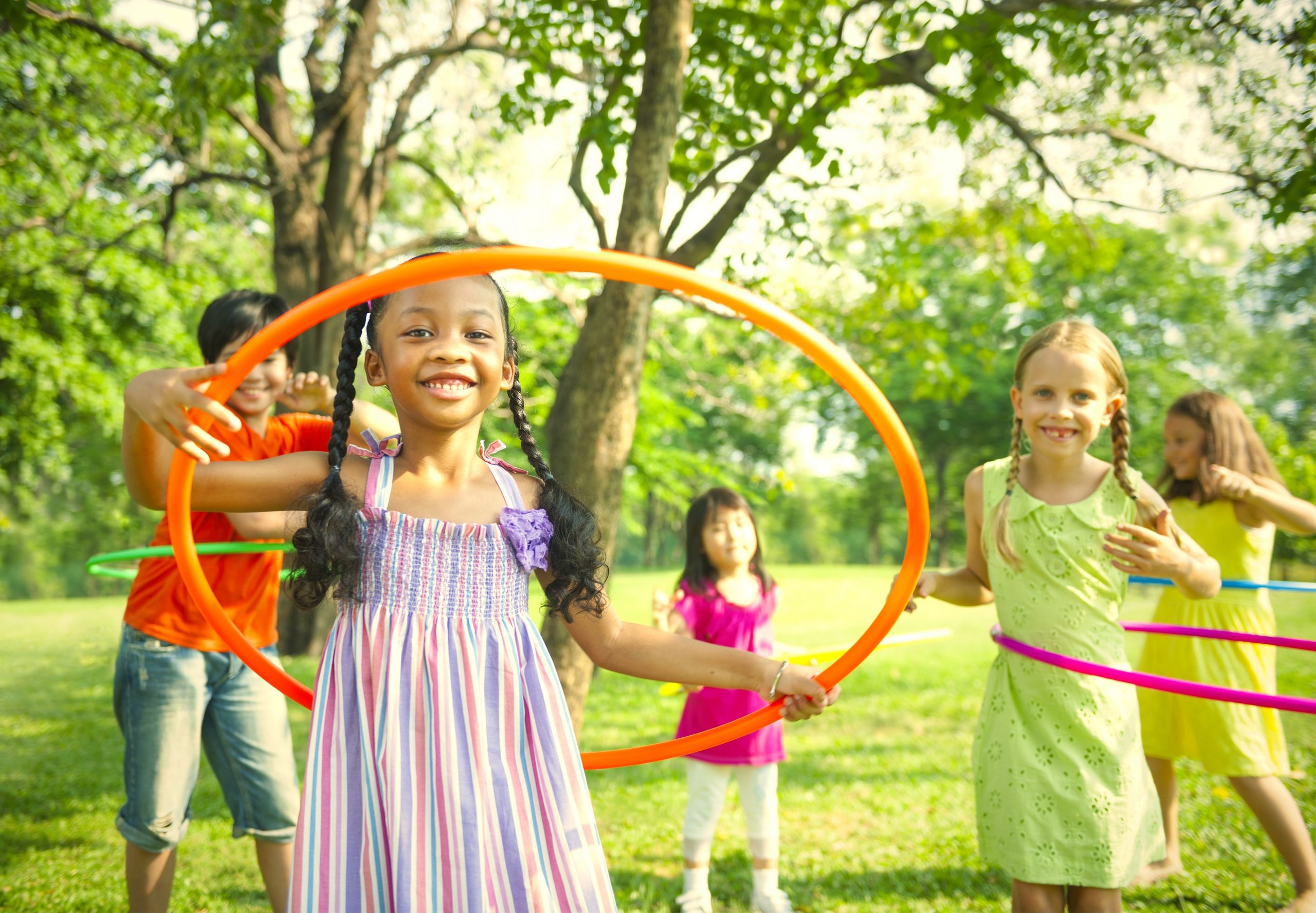 Kids spinning hula hoops in a park