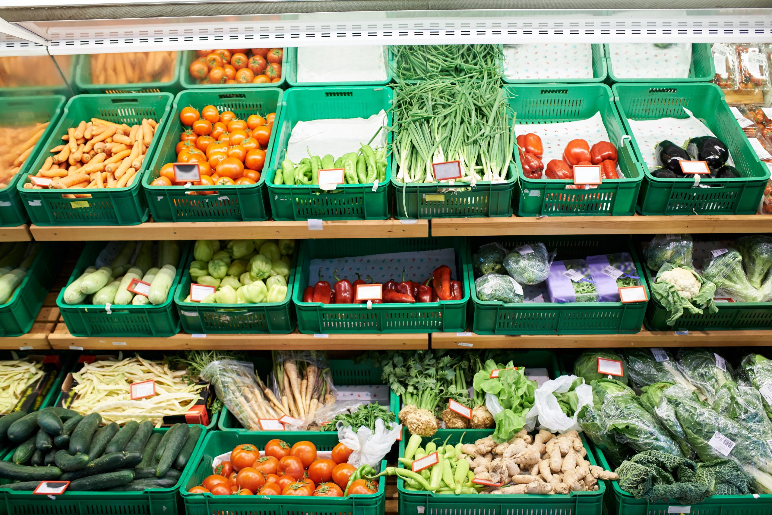 Fruits and vegetables at market Fruits and vegetables in green bins at a market