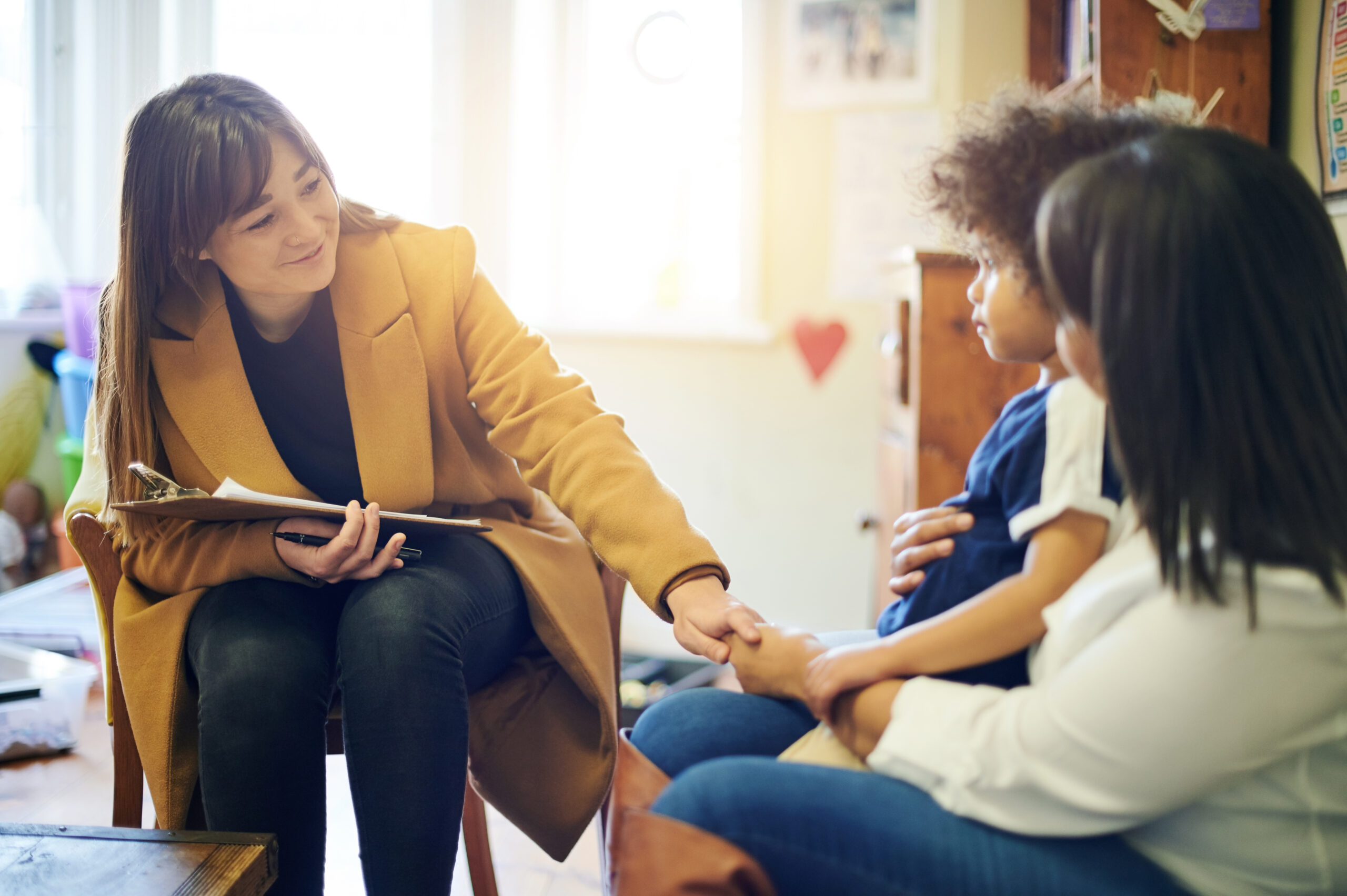 Mother, child and psychologist consultation in office for support, help and mental health.