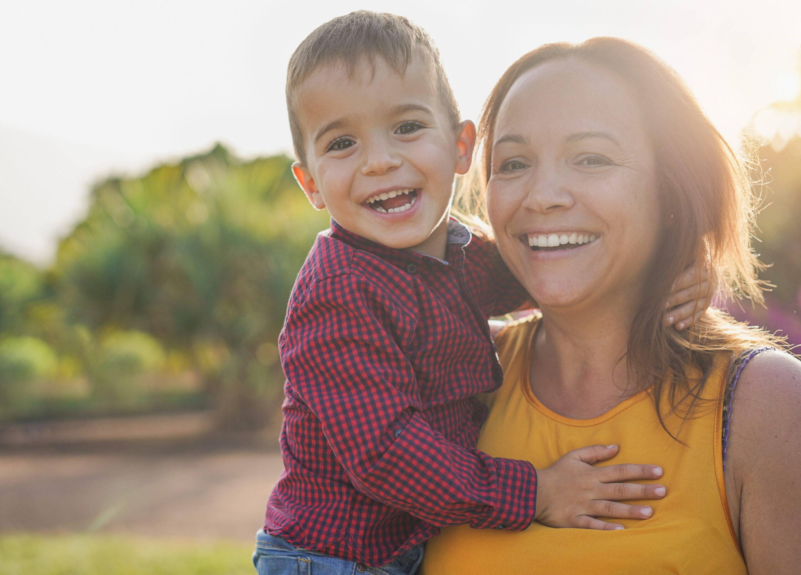 Happy young mother with her son in her arms looking in camera