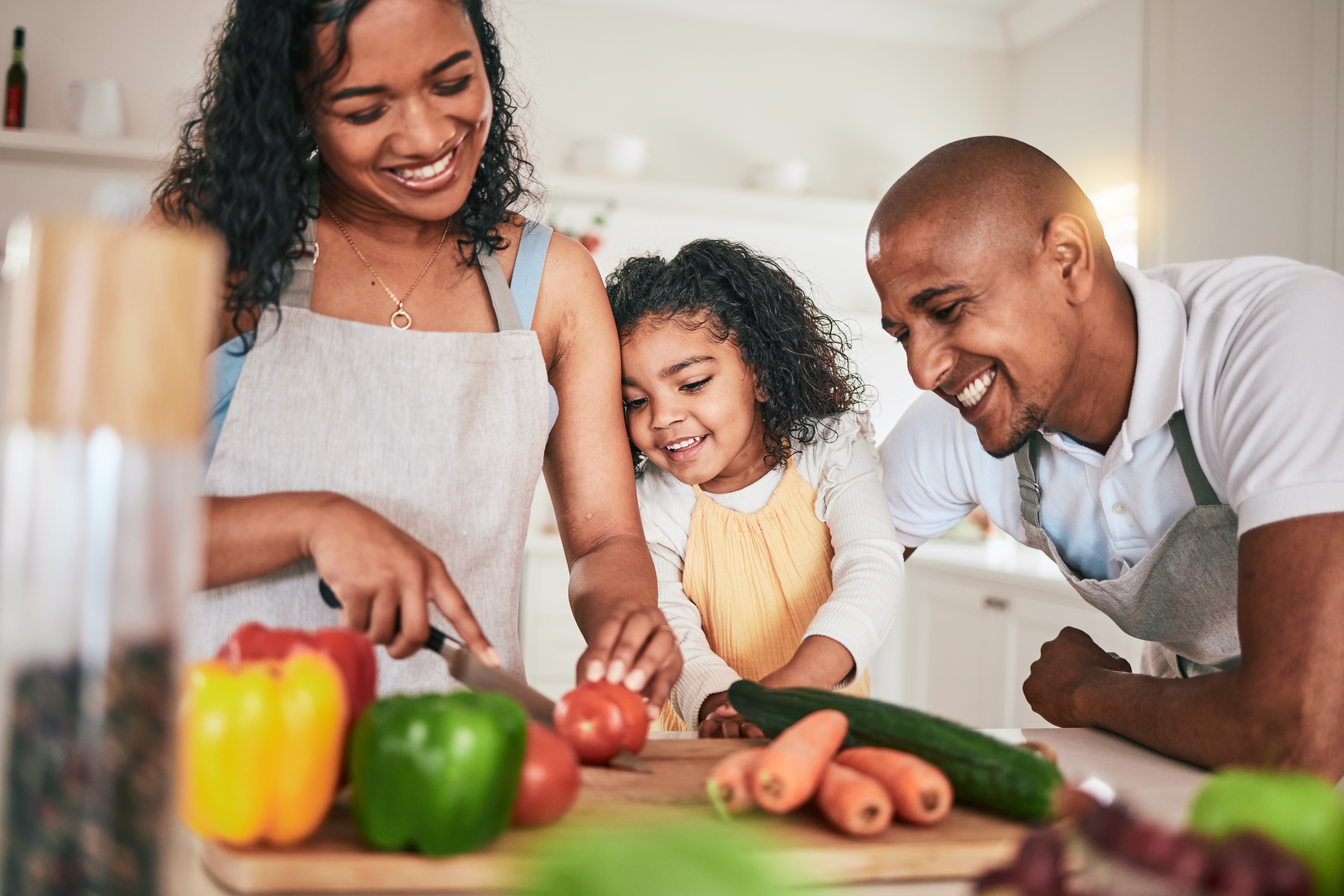 Family, cut and cooking vegetables together or learning chef skill with parents and child in kitchen.