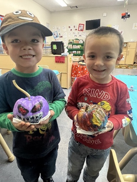 Children holding their painted pumpkins
