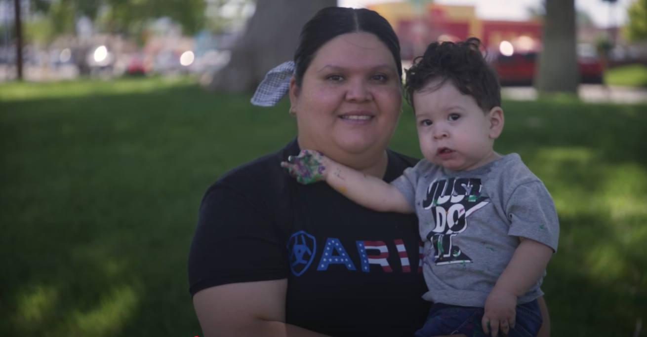 A mother holding her child in a park